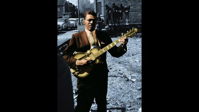 Little Walter, known for his revolutionary harmonica style, poses on Maxwell Street with his guitar in 1963. Raeburn Flerlage image, colorized.
