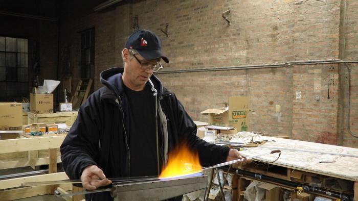 Neon Design owner Charles Evanson bends glass in Rogers Park.