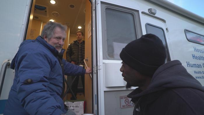 Volunteer Jim Lacy speaks with a man at the Night Ministry’s outreach bus. (Chicago Tonight)