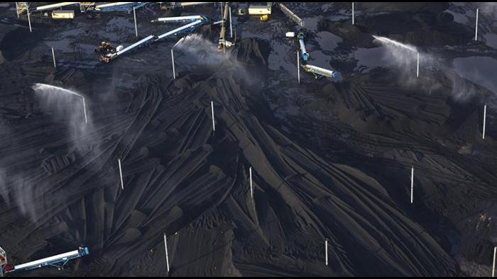 Petcoke piles with sprinklers at KCBX site on Calumet River, 2014. (Terry Evans / Courtesy of Museum of Contemporary Photography)