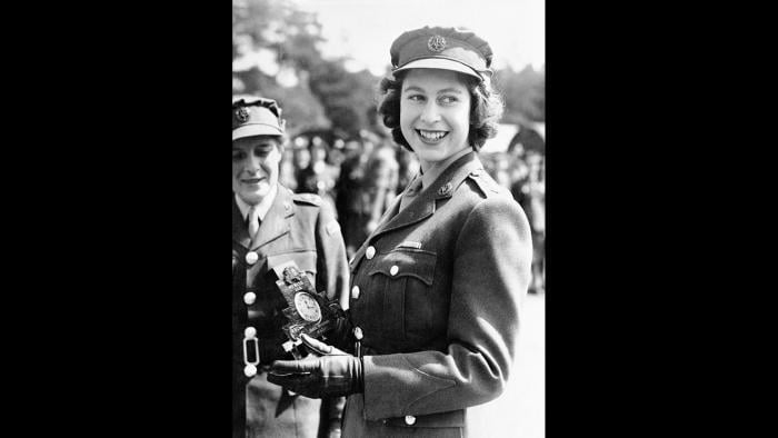 Britain’s Princess Elizabeth, a Junior Commander in the Auxiliary Territorial Service, receives a clock presented to her by her old associates at the camp where she received her early training, during a ceremony at the No. 1 M.T. Training Center, in Camberley, England, Aug. 3, 1945. (AP Photo, File)