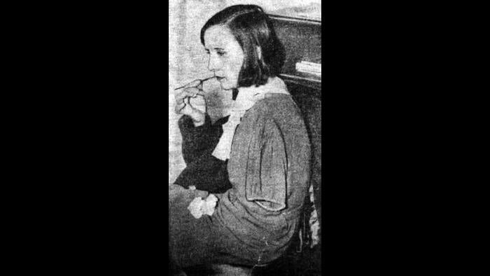 Charlotte Purcell, a dial painter in Ottawa, Illinois, demonstrates lip-pointing. (Chicago Daily Times, courtesy of Sun-Times Media)
