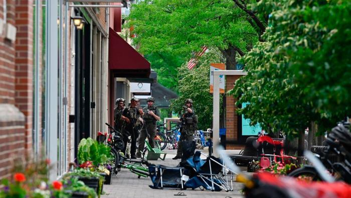 Police search the downtown area of the Chicago suburb of Highland Park, Ill., after a mass shooting at a Fourth of July parade Monday, July 4, 2022. (Tyler Pasciak LaRiviere / Chicago Sun-Times via AP)
