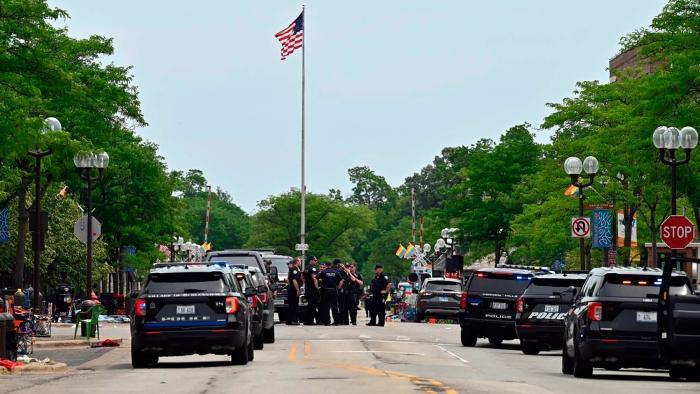 Police search the downtown area of the Chicago suburb of Highland Park, Ill., after a mass shooting at a Fourth of July parade Monday, July 4, 2022. (Tyler Pasciak LaRiviere / Chicago Sun-Times via AP)