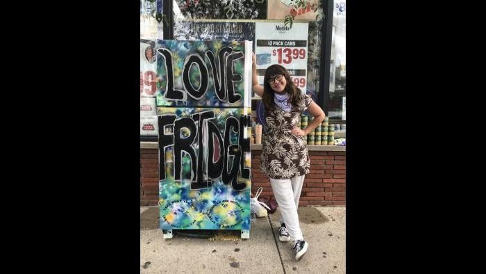 Allie Mae Miller stands next to the refrigerator she painted and donated to the Love Fridge project in Avondale. (Ariel Parrella-Aureli / WTTW News)