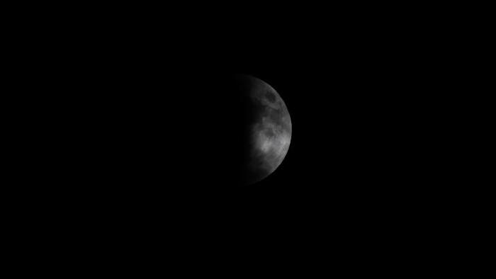 Photo by Michal Furmanek: Lunar Eclipse, moon partially behind clouds