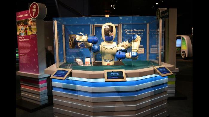 A FANUC robot plays blackjack with guests at the 'Robot Revolution' exhibit. (Maya Miller / Chicago Tonight)
