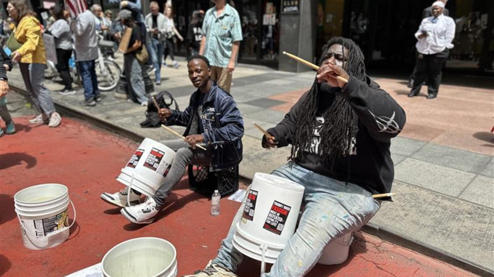 Chicago’s staple “bucket boys” keep the rhythm for protesters chanting “Dump Trump” on Saturday, June 14, 2025. (Abena Bediako / WTTW News)