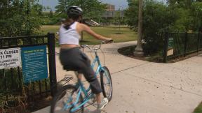 A cyclist enters the 606 trail in Chicago on its reopening date Monday, June 22, 2020. On Friday, the city and state will move into phase four of reopening plans. (WTTW News) A cyclist enters the 606 trail in Chicago on its reopening date Monday, June 22, 2020. On Friday, the city and state will move into phase four of reopening plans. (WTTW News)