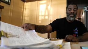 Chicago School Board candidate, rapper Che “Rhymefest” Smith, looks over signature petitions for his candidacy during an interview with The Associated Press at his home in the Chatham neighborhood of Chicago, Tuesday, May 21, 2024. (AP Photo / Charles Rex Arbogast)
