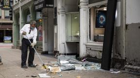 A man sweeps up outside Paul Young Fine Jewelers after looting broke out in the Loop and surrounding neighborhoods overnight, Monday morning, Aug. 10, 2020 in Chicago. (Ashlee Rezin Garcia / Chicago Sun-Times via AP) A man sweeps up outside Paul Young Fine Jewelers after looting broke out in the Loop and surrounding neighborhoods overnight, Monday morning, Aug. 10, 2020 in Chicago. (Ashlee Rezin Garcia / Chicago Sun-Times via AP)