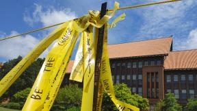 Handwritten messages on yellow ribbon comprise the installation “Dirty Laundry” on the lawn at Carl Schurz High School. (Erica Gunderson / WTTW News) Handwritten messages on yellow ribbon comprise the installation “Dirty Laundry” on the lawn at Carl Schurz High School. (Erica Gunderson / WTTW News)