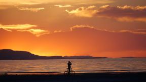 A man on a bike photographs the sunset at the Great Salt Lake Thursday June 13, 2024, near Salt Lake City. (AP Photo / Rick Bowmer)
