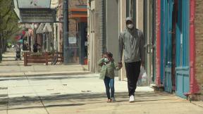Family members wearing masks walk along the sidewalk in the Humboldt Park neighborhood on Thursday, May 7, 2020. Under Gov. J.B. Pritzker’s stay-at-home order, all residents should wear face masks or coverings when social distancing is not possible. (WTTW News) Family members wearing masks walk along the sidewalk in the Humboldt Park neighborhood on Thursday, May 7, 2020. Under Gov. J.B. Pritzker’s stay-at-home order, all residents should wear face masks or coverings when social distancing is not possible. (WTTW News)