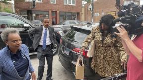 Mayor Lori Lightfoot hits the campaign trail on June 7, 2022, as her security detail looks on. (Heather Cherone / WTTW News)