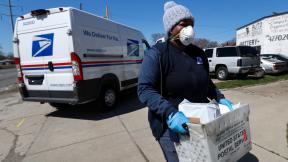 In this April 2, 2020 file photo, a United States Postal Service worker makes a delivery with gloves and a mask in Warren, Mich. I(AP Photo / Paul Sancya, File) In this April 2, 2020 file photo, a United States Postal Service worker makes a delivery with gloves and a mask in Warren, Mich. I(AP Photo / Paul Sancya, File)