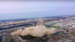 A still image from a video taken of the demolition of the Crawford Coal Plant smokestack, April 11, 2020. (Alejandro Reyes / YouTube)