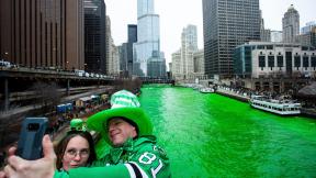 FILE - Stacey Peterson and Kevin McGuire take a selfie in front of the green Chicago River to celebrate St. Patrick’s Day, Saturday, March 17, 2018. (James Foster / Chicago Sun-Times via AP, File)