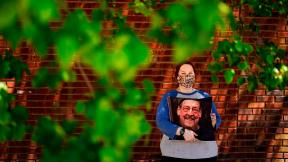 Sara Atkins poses for a photo, in Wynnewood, Pa., Tuesday, May 10, 2022, while holding a pillow with an image of her father Andy Rotman-Zaid, who died of COVID-19 in December 2020. She channels her grief into fighting for global vaccination and better access to health care to honor her father. (AP Photo / Matt Rourke) Sara Atkins poses for a photo, in Wynnewood, Pa., Tuesday, May 10, 2022, while holding a pillow with an image of her father Andy Rotman-Zaid, who died of COVID-19 in December 2020. She channels her grief into fighting for global vaccination and better access to health care to honor her father. (AP Photo / Matt Rourke)